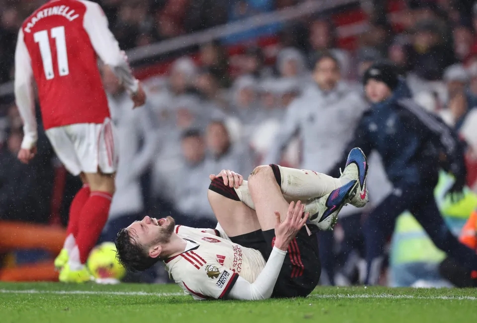 Cầu thủ Bradley ôm đầu gối đau đớn, Martinelli rời xa.